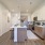 Modern Lakewood apartment kitchen with wood-grain cabinets, island, and white counters.
