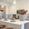 Open-concept kitchen with white cabinets, island seating, and stainless steel appliances at Lakewood apartments.