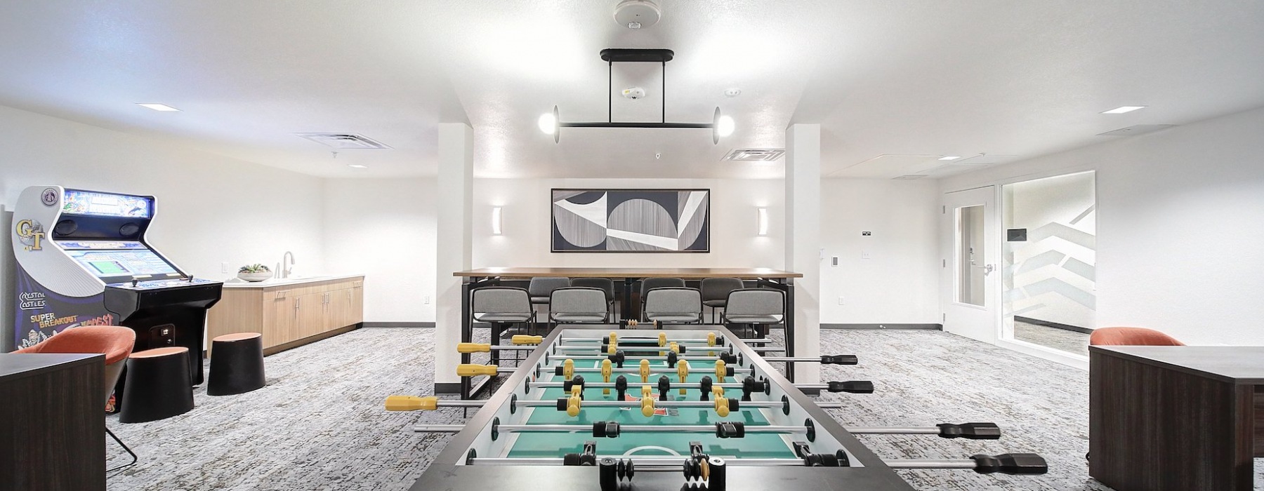 Game room with foosball, arcade game, and shuffleboard