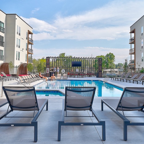 Sparkling swimming pool Lakewood apartment swimming pool with lounge seating and dining tables.
